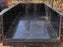 HDPE trailer liner as a plywood wainscot panel inside an enclosed cargo trailer in the woods
