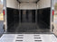 Black HDPE trailer liner inside an enclosed cargo trailer with aluminum walls and a ramp door
