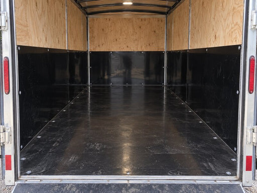 Black HDPE trailer liner as a wainscot panel over plywood walls inside an enclosed cargo trailer
