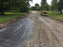 Roller compacting gravel over woven driveway stabilization fabric
