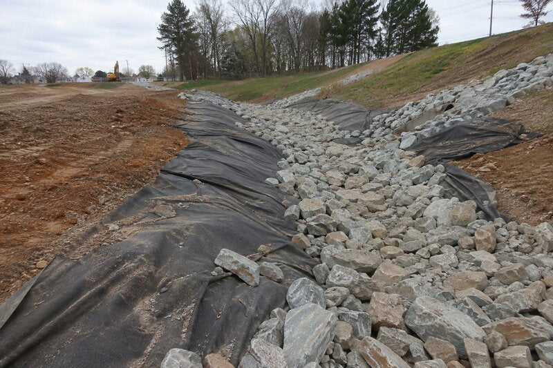 Geotextile fabric under a rock-lined drainage channel

