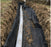 Heavy-duty drainage fabric in a deep yard drainage trench
