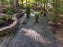 Heavy-duty weed barrier along a woodland garden pathway
