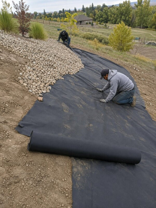 Landscape weed barrier fabric installed on a hillside
