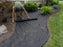 Laying polyspun landscape weed barrier fabric in a garden bed
