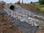 Non-woven geotextile fabric installed under riprap at a culvert outlet for erosion control
