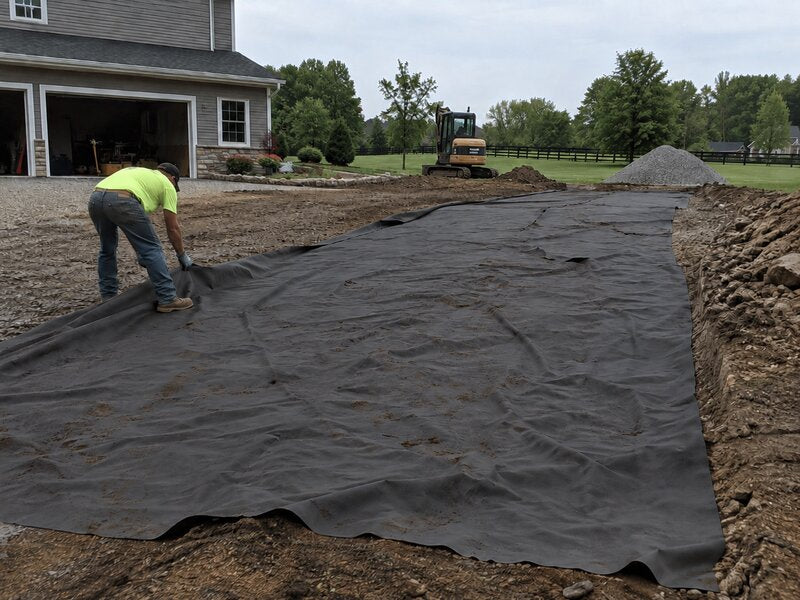 Non-woven geotextile fabric laid as a road base separator on a rural farm driveway
