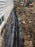 Non-woven geotextile fabric wrapping a foundation drain trench along a house exterior
