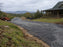 Non-woven geotextile fabric roll laid out under crushed gravel for a rural driveway base
