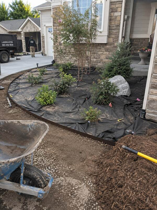 Non-woven geotextile fabric used as a weed barrier under mulch in a landscaped planting bed
