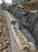 Non-woven geotextile fabric wrapping drainage gravel behind a curved segmental block retaining wall
