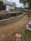Non-woven geotextile fabric wrapping drainage gravel behind a block retaining wall

