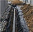 Non-woven geotextile fabric lining a French drain with perforated pipe
