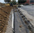Heavy-duty non-woven geotextile in a parking lot edge drainage trench
