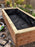 Non-woven raised bed liner fabric fitted inside a backyard wood planter box

