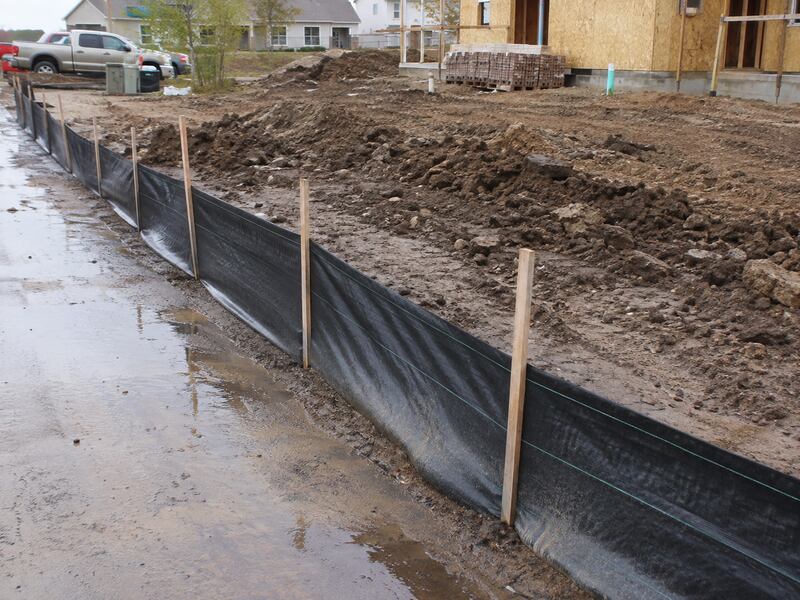 Silt fence on wood stakes along a construction site perimeter
